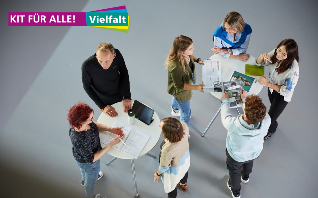 Personen mit verschiedenem Migrationshintergrund stehen an einem Tisch